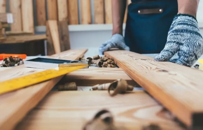 Man with gloves working on DIY fence building